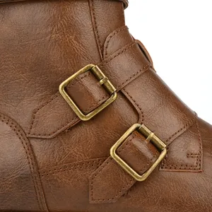 Close-up detail of retro brown leather boot featuring dual bronze metallic buckles