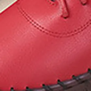 Macro-detailweergave van het rode getextureerde leer en stiksels op warme winterlaarzen
