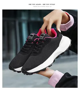 Detailed view of black mesh sneakers featuring pink lining and chunky white soles.
