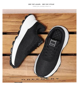 Detailed view of breathable black mesh sneakers for teenagers on wooden background.
