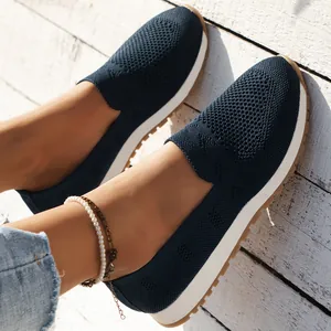 Detailansicht von atmungsaktiven dunkelblauen Flyknit-Slippern auf weißem Holzboden