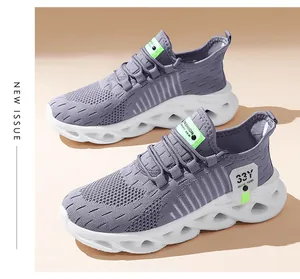 Vue détaillée de baskets de sport grises en maille respirante avec semelles blanches.