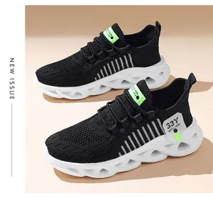Détail latéral des baskets en maille respirante noir et blanc pour garçons avec accents