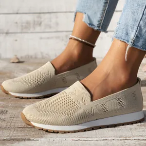 Detailansicht beige atmungsaktive Strick-Slipper für Damen auf Holzuntergrund