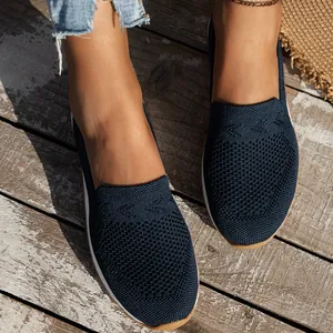 Detailansicht der dunkelblauen, atmungsaktiven Slip-On-Flats aus Flyknit auf Holz