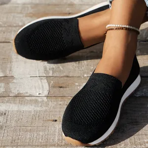 Detailaufnahme der atmungsaktiven schwarzen Fly-Knit Slipper mit Perlen-Fußkettchen.