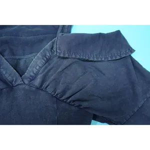 Detailed macro view of the washed vintage fabric and seams of a dark blue bodysuit
