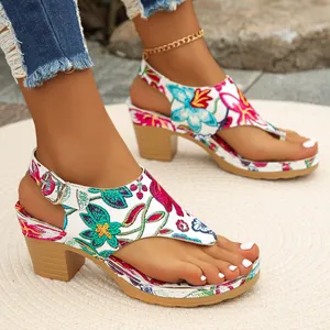 Detailansicht von Damen-Zehentrenner-Sandalen mit Blumenstickerei und Blockabsatz.