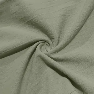 Macro dettaglio del tessuto in lino verde salvia traspirante di questi pantaloni da mare