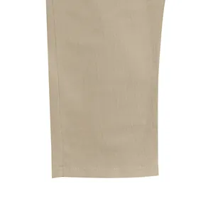 Primo piano del tessuto in lino beige traspirante e dell'orlo di un pantalone da spiaggia uomo.
