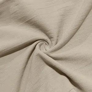 Dettaglio ravvicinato del tessuto in lino beige traspirante per pantaloni estivi.