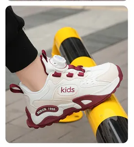 Detailed side view of children's white and maroon sports sneakers featuring rotary buckle closure