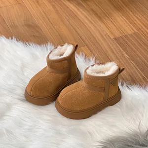 Cozy brown children's snow boots with white faux fur lining on a soft white rug.