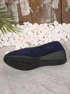 Detailansicht eines marineblauen Wildleder-Keilschuhs mit LOVE-Muster auf der Sohle.