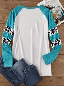 Vista dettagliata di una maglietta a maniche raglan con maniche patchwork turchesi e mucca