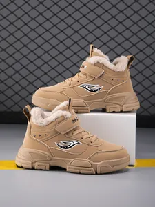 Vista lateral de botas de invierno color crema para niños con forro polar cálido