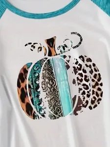 Dettaglio stampa zucca artistica su maglia bianca a maniche raglan
