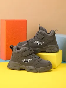 Detalle lateral de botas de invierno para niños con forro de piel sintética gris y suela antideslizante