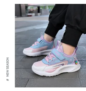 Modische Kinder-Sneaker aus Leder in Rosa und Blau, im Freien auf Pflaster getragen