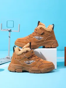 Vista lateral detallada de botas de invierno marrones para niños con forro de piel sintética.