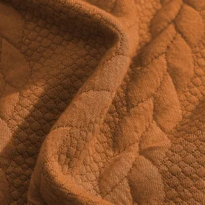 Κοντινό πλάνο πορτοκαλί υφάσματος jacquard με καπιτονέ σχέδιο σε σχήμα αστεριού