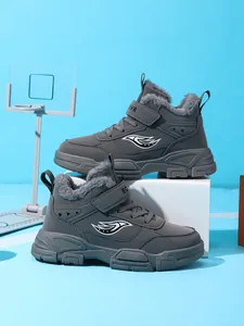 Detalle de botas de invierno grises para niños con forro de piel y logo lateral