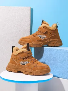 Detalle de botas de invierno marrones para niños con forro de piel sintética y suela