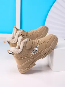 Detalle de botas de invierno caqui para niños con forro polar cálido.