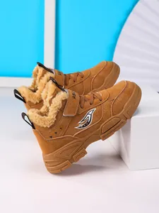 Detalle lateral de las botas de invierno marrones para niños con forro polar cálido