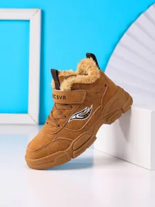 Detalle de bota de invierno para niños con forro de piel sintética cálida y suela marrón