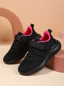 Detail van ademende kindersneakers met roze voering en klittenbandsluiting.
