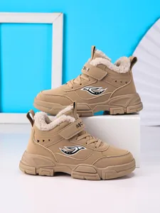 Detalle de cerca de botas de invierno caqui para niños con forro de piel sintética y velcro