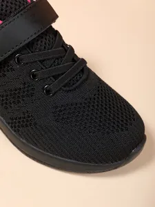 Detailopname van zwart ademend mesh-materiaal op lichtgewicht sportsneakers voor meisjes
