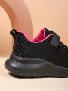 Close-up van zwarte ademende mesh sportschoen voor meisjes met roze voering en hiel.