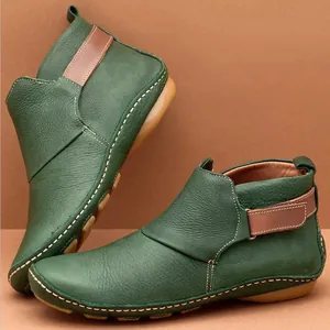 Gros plan de bottines en cuir vert style romain rétro avec détail de bride marron