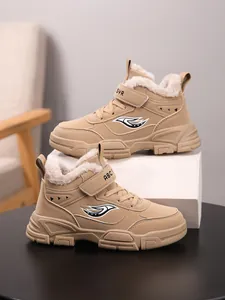 Primer plano de botas de invierno caqui para niños con forro de felpa gruesa y velcro