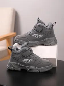 Primer plano de botas de invierno grises para niños con forro polar y logotipo de ala.