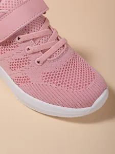 Detailopname van het ademende roze mesh-materiaal op een meisjessportschoen