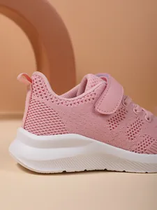 Detailopname van ademend roze mesh bovenwerk en witte zool op hardloopschoenen voor meisjes