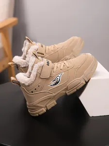 Detalle de botas de invierno beige para niños con forro de piel sintética y suela antideslizante