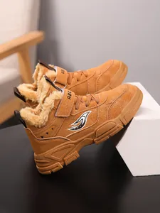 Detalle de botas de invierno cálidas para niños con forro de piel sintética gruesa y suela