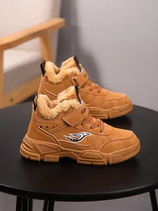 Vista detallada de botas de invierno marrones para niños con forro de piel sintética.