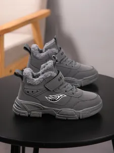Primer plano de botas de invierno grises para niños con forro de piel