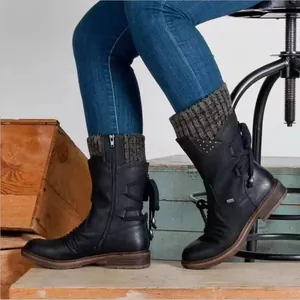 Detalle lateral de botas negras de media caña para mujer con puños de punto y cordones