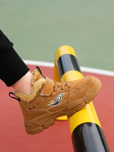 Detalle de botas de invierno para niños en color marrón con forro de piel gruesa y suela.
