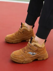 Primer plano de botas de nieve marrones para niños con forro polar usadas al aire libre