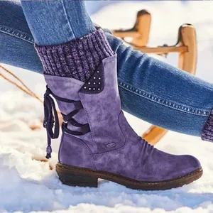 Vista detallada de botas de nieve retro moradas con puño de punto cálido en la nieve