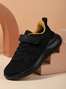 Zijaanzicht ademende zwarte mesh meisjessneakers met gele voering op geometrische steunen