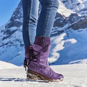 Vista detallada de botas de nieve moradas con cuellos de punto en un entorno nevado