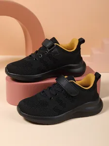 Gedetailleerd overzicht van zwarte ademende mesh kindersneakers met gele voering.